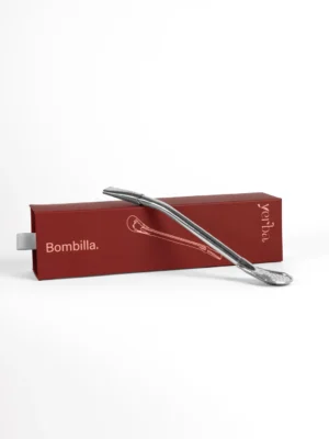 Stainless steel bombilla resting on its red Yerba box
